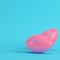 Pink american football ball on bright blue background in pastel colors