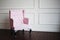 Pink armchair against wall. Perspective distortion and free space