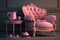 a pink armchair with a tray on the armrest and a cup of tea