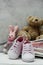 Pink baby girl shoes, newborn clothes and soft toys. Motherhood, education or pregnancy concept with copy space. Greeting card