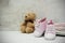 Pink baby girl shoes, newborn clothes and soft toys. Motherhood, education or pregnancy concept with copy space. Greeting card