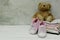 Pink baby girl shoes, newborn clothes and soft toys. Motherhood, education or pregnancy concept with copy space. Greeting card