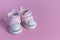 Pink baby shoes on a gentle pink background. The concept of the first steps, birthday, expectation, pregnancy, motherhood,