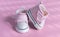 Pink baby shoes on a gentle pink background. The concept of the first steps, birthday, expectation, pregnancy, motherhood,