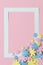 Pink background with colorful flowers and frame for text.