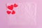 Pink background with red hearts. Crumpled pink paper on a pink background and hearts.