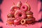 Pink background with various donuts and sprinkles