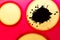 Pink background with yellow circles and black spot.Black drop with splashes