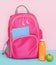 Pink backpack with snack of fruit smoothie bottle and apple. Back to school concept