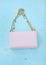 Pink bag on a gold chain. Golden sequins. Blue background