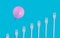 Pink balloon over forks on a blue background