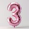 A pink balloon shaped like the number 3