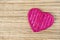 Pink bamboo wood heart on reed texture background, love and romance symbol