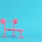 Pink barbell with bench with ball on bright blue background in pastel colors. Minimalism concept