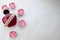 A pink beautiful glass transparent bottle of female perfume adorned with white drab pearls and pink paraffin candles in the shape