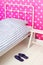 Pink bedroom with bed and slippers