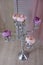 Pink and beige colored studio decorations. Silver sconce candelabrum standing on wooden floor close to wood screen with beige airy