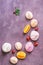 Pink and beige meringue is beautifully located on a purple abstract background with strawberries, cherries and orange slices. Copy