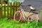 Pink bike leaning on doghouse with picket fence