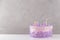 Pink birthday cake with colorful blown out candles