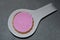 Pink biscuit on white spoon