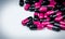 Pink-black capsule pills on white table. Antibiotics drug resistance. Global healthcare. Antimicrobial capsule pills. Pharmacy