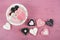 Pink, black and white homemade heart shape cookies on vintage shabby chic pink wood background