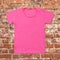 Pink blank t-shirt on dark brick background