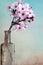 Pink blooming cherry flowers in an old tincture glass bottle. Close Up