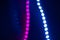 Pink and blue blurry neon bokeh lights on black. Abstract background of 80s colors