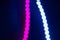 Pink and blue blurry neon led strip lights on black. Abstract background of 80s colors