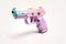 A pink and blue gun on a white surface. Generative AI image. Stop gun violence.