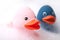 Pink and blue rubber duck toys with moss in bath