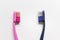 Pink and blue toothbrushes in front of each other