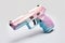 A pink and blue toy gun on a white surface. Generative AI image. Stop gun violence.