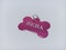 Pink bone-shaped dog pendant with name and phone number on the back