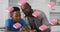 Pink book icons in seamless motion against african american father helping son with homework