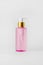 Pink bottle with hydrophilic oil on a light background.