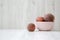 Pink bowl of ripe peaches on white wooden background, side view