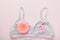 Pink Breast Cancer Awareness Ribbon. Gerbera and pink ribbon tape lying on female white bra on backgrounds. Breast cancer