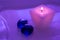 A pink burning candle with glass blue pebbles. Candle for spa salons. Purple toning.