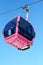 Pink cable car cabin on blue sky as background