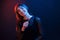 With pink candy in hand. Studio shot in dark studio with neon light. Portrait of young girl