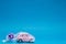 A pink car figurine packed up, on blue background