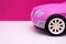 Pink car on a pink background. Concept of car sale, car rental or car rental.