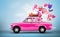 Pink car with symbols of love, holiday, happyness