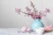 Pink cherry blossom flower bouquet with coffee cup, macaroons and gift box in blue vintage vase