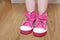 Pink children shoes on standing floor legs