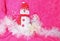 Pink Christmas background smiling snow white snowman with white hibiscus flowers and white tinsle