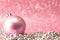 Pink Christmas tree toy and silver garland on a pink background with crystals and bokeh. Christmas card. Copy space. Soft focus